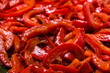 Grilled pepper sliced in stripes. Red pepper background.