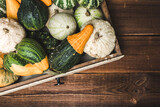 Fototapeta Kuchnia - Fresh pumpkins in the box on wooden background. Decorative vegetables harvest. Autumn Thanksgiving background.