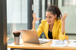 © Tj - Stressed business woman feeling frustrated and overwhelmed, expressing anger and yelling while working on a laptop in a modern office, symbolizing professional burnout and workplace pressure