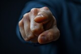 Close-up of a human hand pointing directly at the viewer creating a sense of accusation or selection