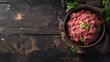 A close-up view of a bowl filled with fresh raw minced beef on an old dark wooden table