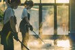 A cleaning team in protective gear pressure washing a sunny outdoor patio. Professional Cleaning Team Pressure Washing Patio