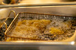 close-up in professional kitchen frying French fries in oil in a deep fryer