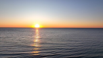 Beautiful morning sunrise over the ocean at the beach with warm sunlight shining on peaceful sea with calm gentle surf and waves at Pawleys Island, South Carolina low country lifestyle by the seashore