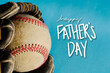 Happy Father's Day background with old baseball ball in glove on blue backdrop for holiday greeting.
