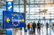© julia_aldo - Busy Airport Terminal with Schengen Sign, European Travel Concept with Copy Space