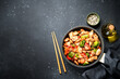 Stir fry chicken and vegetables and sesame at black background. Asian cuisine. Top view with space for design.