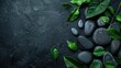 Black spa setting, hot stones and beautiful leaves. Spa and wellness background with stack of hot stones on blackboard. Luxury spa composition and relax concept.