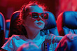 © Image-Love - A young girl wearing sunglasses sits in a dark theater. She is looking at the screen with a smile on her face