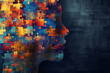 Human head formed from colorful jigsaw puzzle pieces on dark background. World autism awareness day, neurodiversity, mental health care, education, child development concept