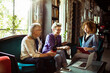 © Davor - Smiling diverse women using smartphone together in office