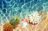 Fototapeta Desenie - Yellow pineapple, seashells and starfish on a blue water background.