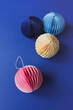 © Yaroslav Danylchenko/Stocksy - Balls decorations made in origami technique laying on blue background