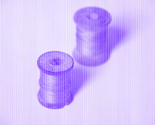 Monotone Purple Image Of Spools Of Thread With White Lines Overlaid