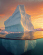 Huge iceberg floating in the arctic sea with a big ice chunk underwater lit by the warm sunset light. Climate change and global warming concept