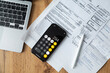 © Danil Nevsky/Stocksy - Smartphone calculator with documents on table