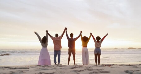 Canvas Print - Friends, group and holding hands on beach for celebration or community goals as environment activist, solidarity or victory. People, back and nature for team building support, sunset or partnership