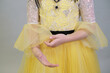 Detail of a glittering yellow dress with delicate tulle and beaded embroidery, perfect for festive and formal children's wear.