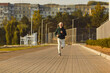 © Studio Romantic - Mature sporty male runner jogging in city park. Healthy sporty fitness man running outdoors training for wellness, health and cardio. Workout in nature and healthy lifestyle concept.