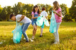 © Studio Romantic - Group of teenage children volunteers with gloves and trash bags collecting garbage in the summer park outdoors. Kids boys and girls cleaning environmental pollution. Ecology concept.