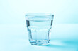 Glass of water on blue background.