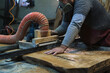 In the workshop, a bandsaw hums as it carves into wood. The craftsman's expertise is evident in the careful handling.