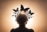 Silhouette of senior woman with butterlies around head