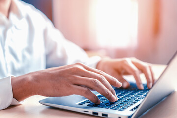 Wall Mural - businessman hand typing on computer keyboard of a laptop computer in office. business and finance co