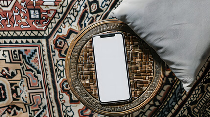 Wall Mural - Mobile phone with blank screen on ornamental wooden table and carpet. Flat lay, top view template with copy space