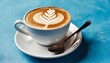a cup of cappuccino on a saucer with a spoon on a saucer on a blue background