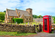 Cotswolds village church with red English telephone box, Gloucestershire, England