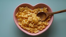   A heart-shaped bowl filled with cereal A wooden spoon rests in the center