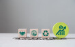 Eco business investment. Green icons on wooden cubes on money coin stack. Green business growth. Finance sustainable development.growing money, finance and investment. Alternative sources of energy.