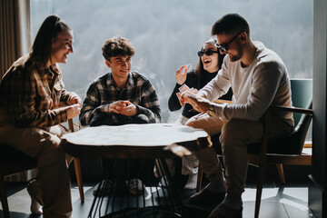 Poster - Casual and fun gathering of young friends engaged in a card game at home, enjoying each other's company.