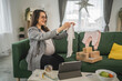 © Miljan Živković - Adult pregnant women have a video call on tablet and share baby wear