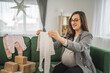 © Miljan Živković - Adult pregnant women have a video call on tablet and share baby wear