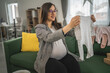 © Miljan Živković - Adult pregnant women have a video call on tablet and share baby wear