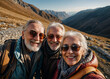 Group of active elderly people travel and take selfies, smiling happily at the camera. Hiking in the mountains.