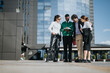 © qunica.com - Diverse business associates engage in a discussion about market strategies and profit growth while standing outside a modern office building.