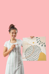 Wall Mural - Female Asian artist with brush and painting on pink background