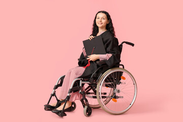 Canvas Print - Beautiful female graduate student in wheelchair with graduation cap on pink background