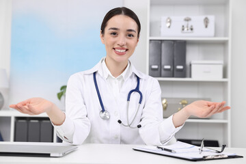 Canvas Print - Medical consultant with stethoscope at table in clinic