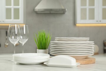 Wall Mural - Clean plates, glasses, butter dish and floral decor on white marble table in kitchen