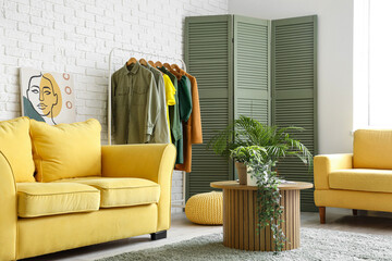 Sticker - Stylish interior of light living room with female clothes and houseplants