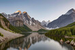 crystal-clear lake reflecting the snow-capped peaks of a majestic mountain range.