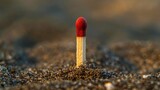 Fototapeta  - A single matchstick standing upright on a bed of sand, Minimalist Matchstick, Symbol of safety and Ignition hazards