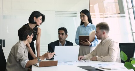 Sticker - Serious male Indian boss instructing team, speaking to listening employees at meeting table with laptop, giving guidance, explaining work task. Business coach training managers, interns