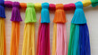 Rainbow color Yarn Tassel Garland stitched to a piece of cloth in selective focus on a wall, 