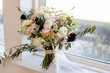 Elegant bridal bouquet basks in soft window light.