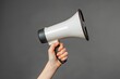 Alert Your Voice with Hand Holding Megaphone - Female Speaker on Grey Background: Support and Public Volume with Loudspeaker Horn